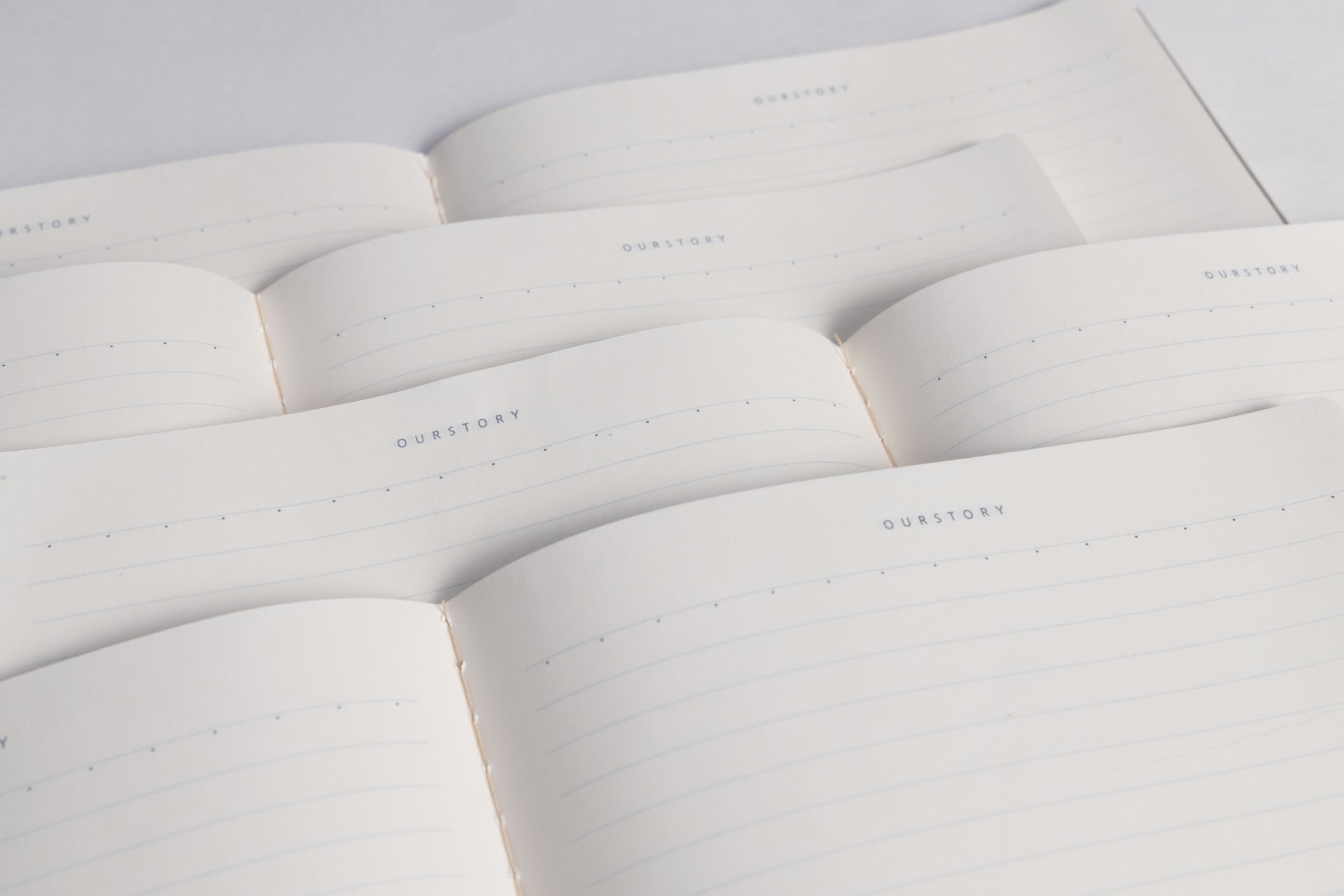 Multiple open minimalist journals showing 180-degree lay-flat thread-bound design, offering a comfortable writing experience for stationery lovers and professionals
