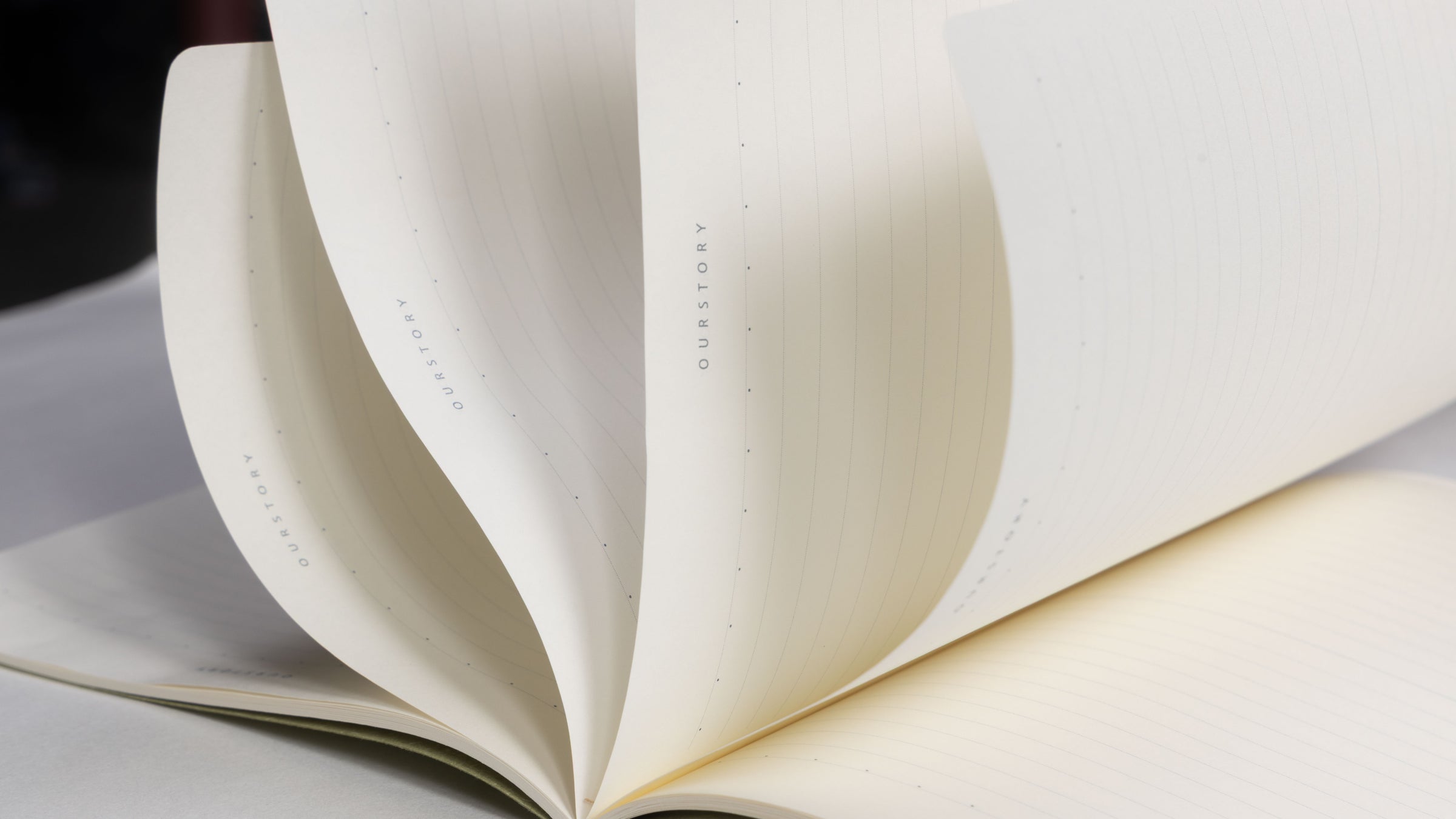 Close up of premium aesthetic lined notebook with fanned pages, featuring high-quality cream paper for bullet journaling, student notes, and professional writing